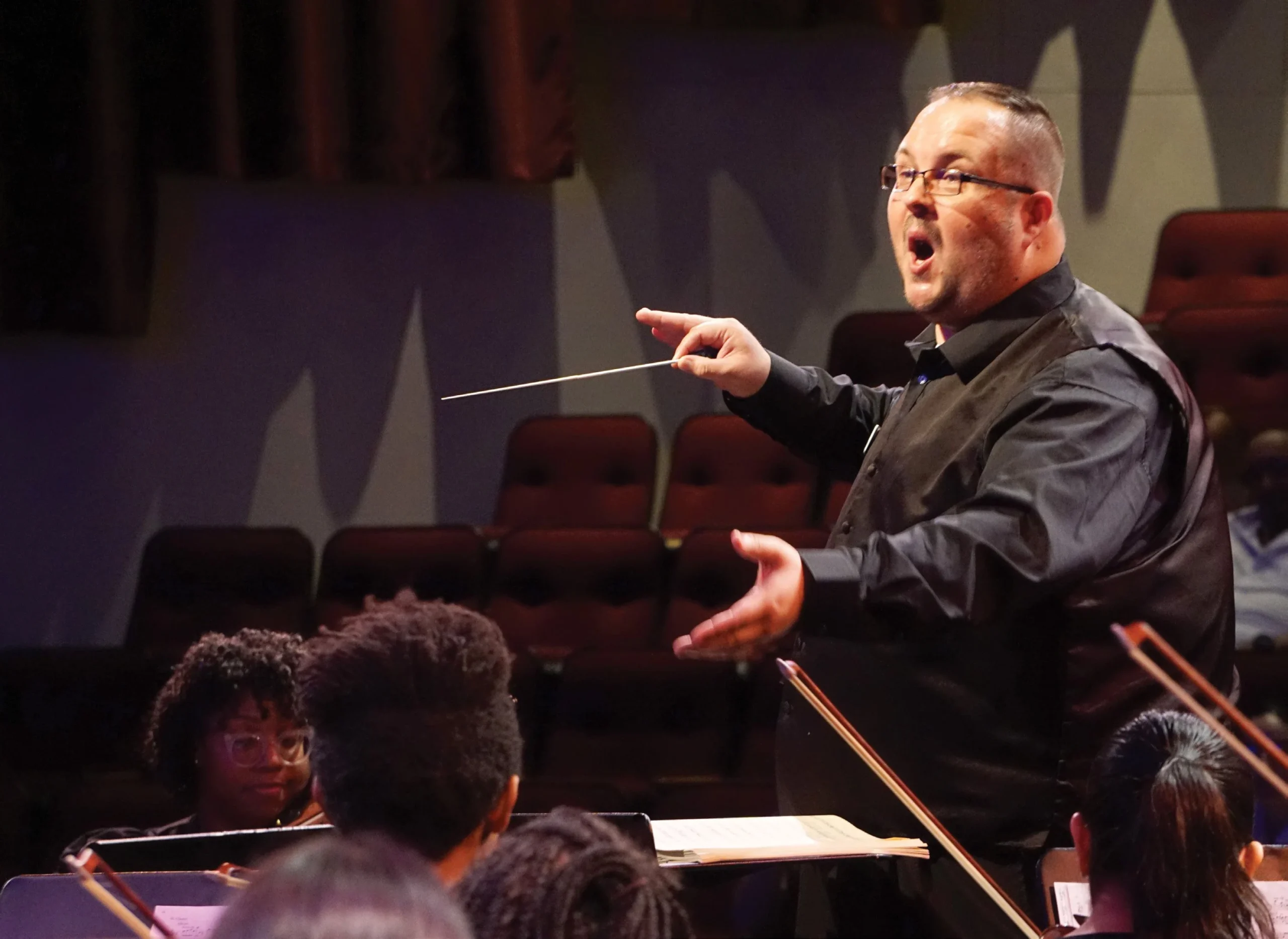 Chad McClellan conducting students playing instruments