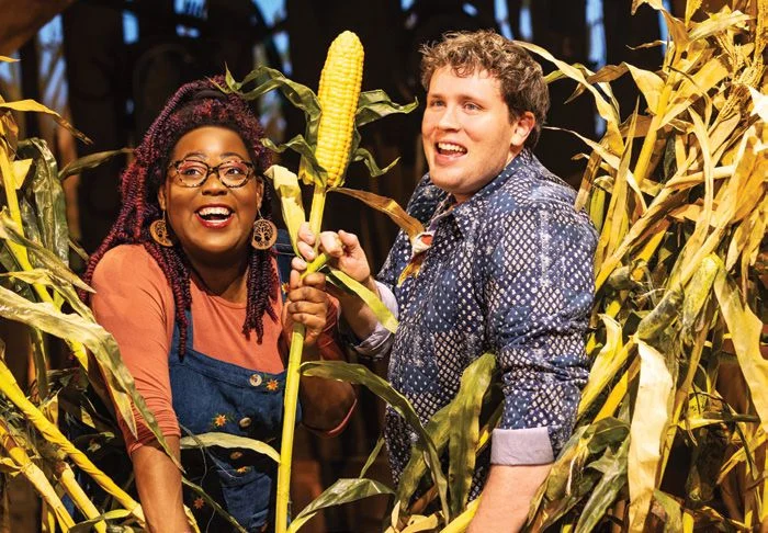 Cast members stand in a corn field