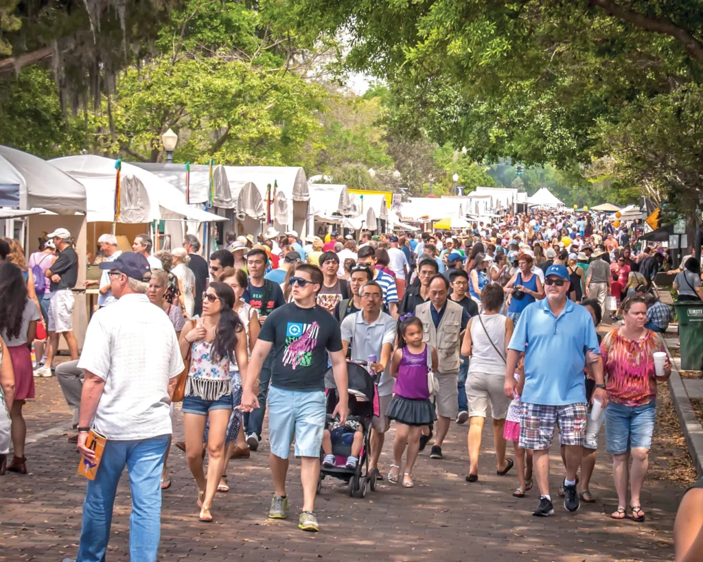 Crowds walk in front of festival tents