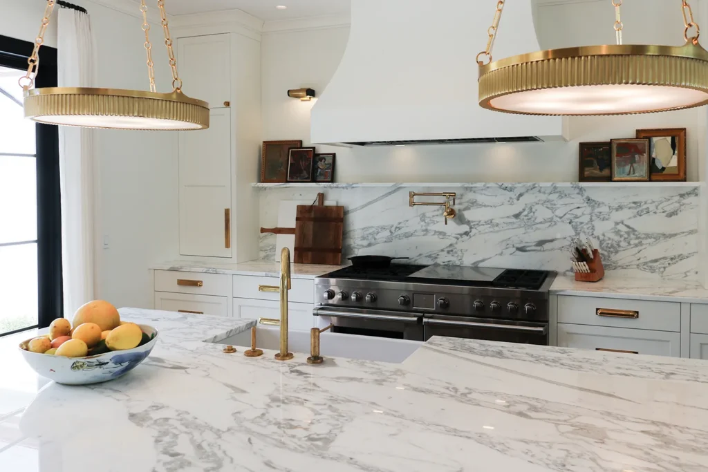 An elegant white kitchen with marble countertops