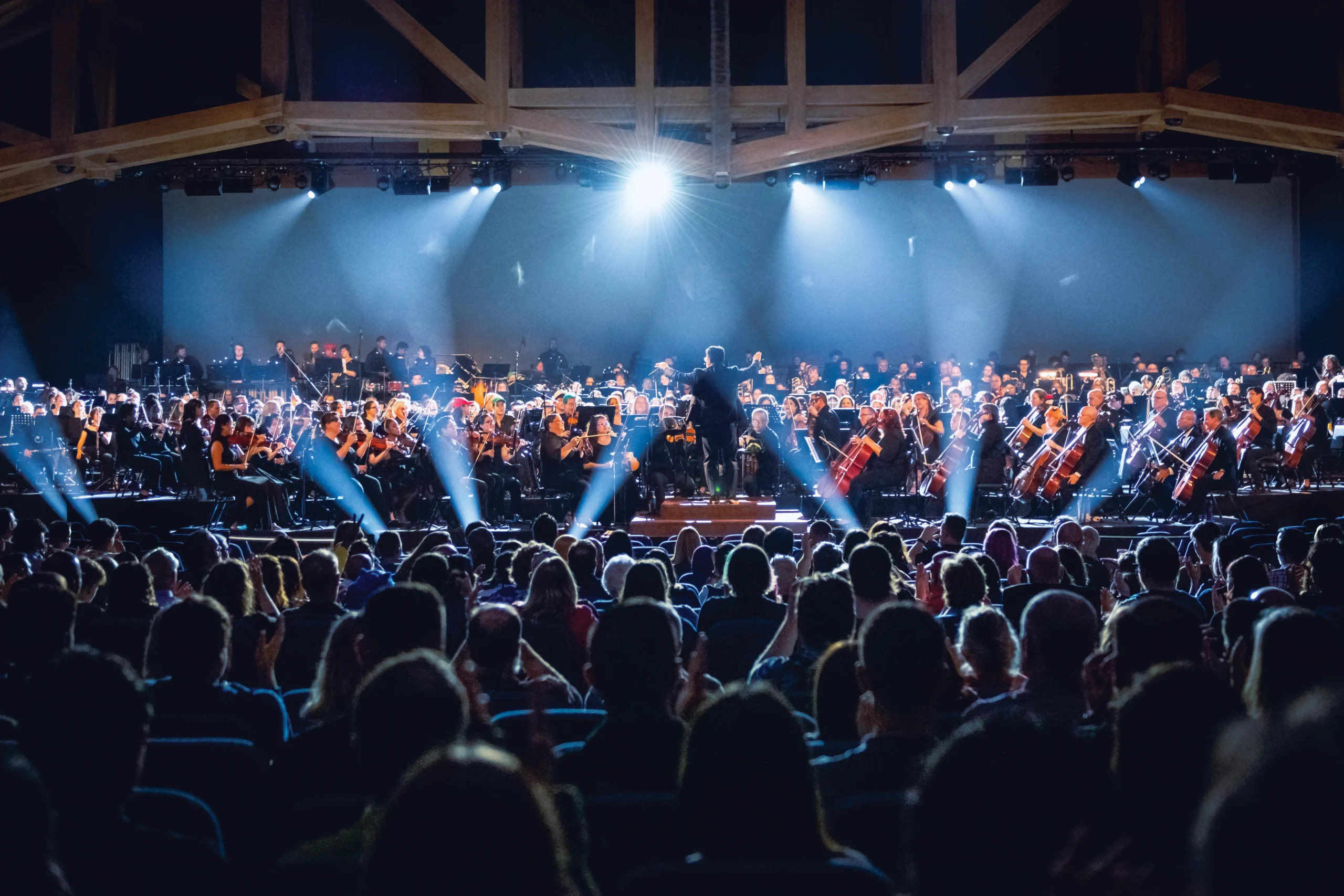 Concert hall with a packed audience and an orchestra on stage