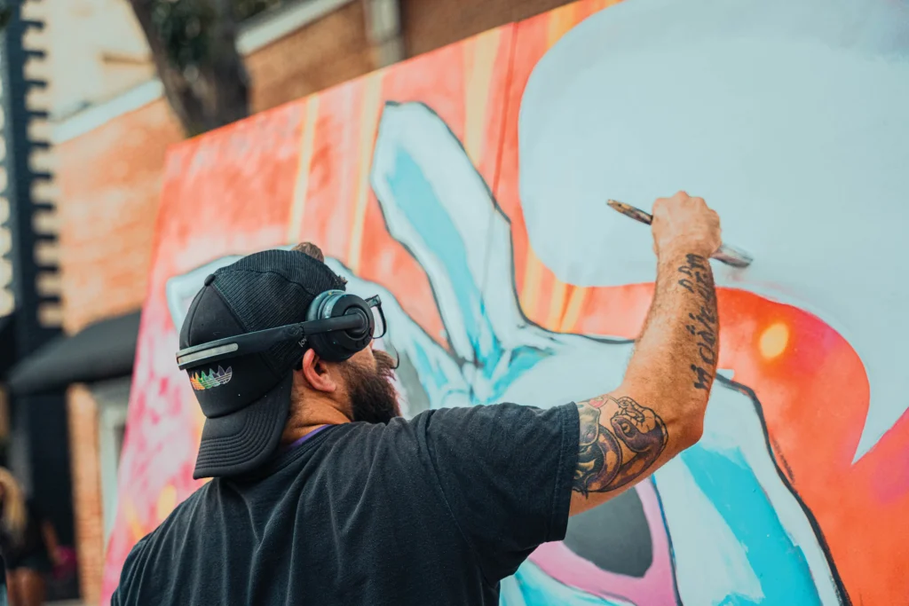 A man painting a colorful mural