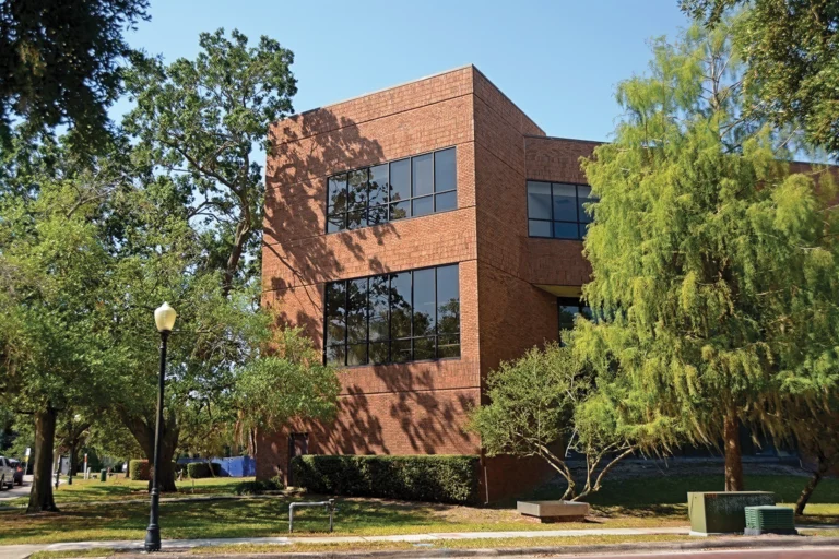 A brick building surrounded by trees