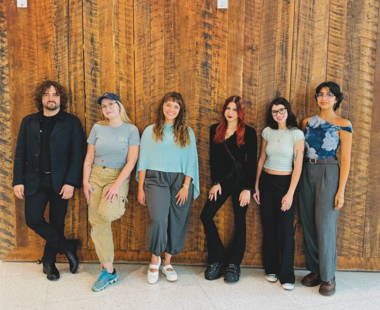 A group of people standing in front of a wall