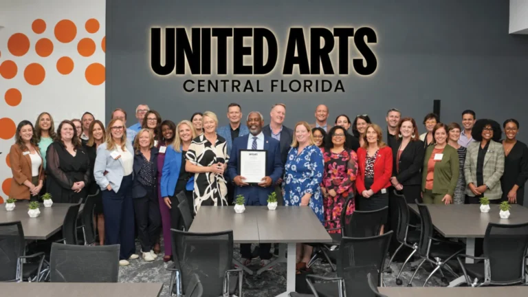Mayor Jerry L. Demings holding an award, surrounded by United Arts of Central Florida staff and board members