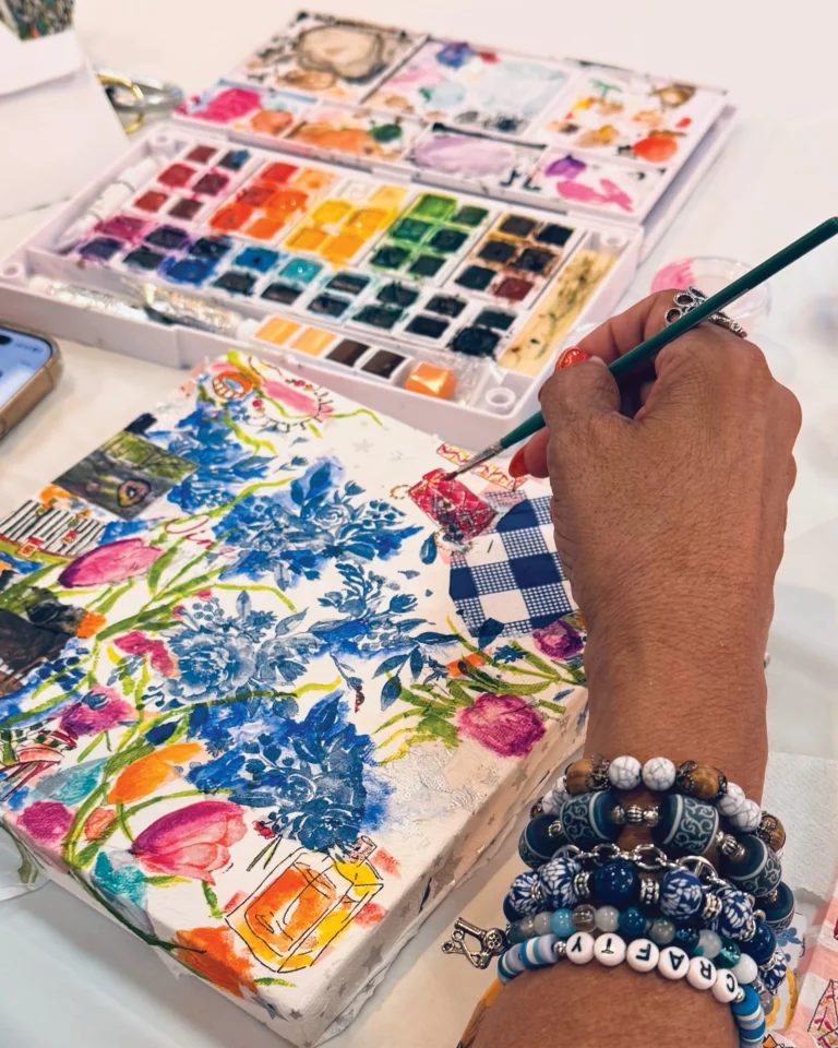 Close-up of an artist painting colorful flowers in watercolor at an art club meeting